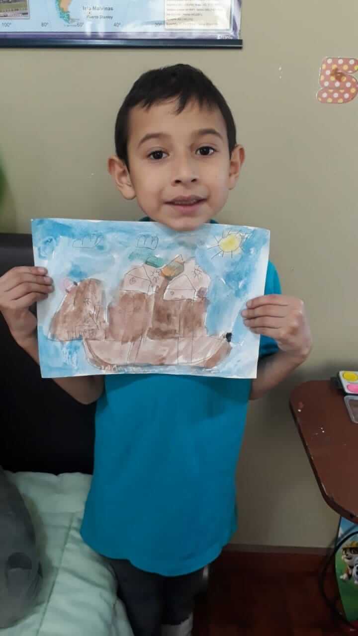 Pequeño artista creando una composición con hojas y flores en Nature's Art Workshop
